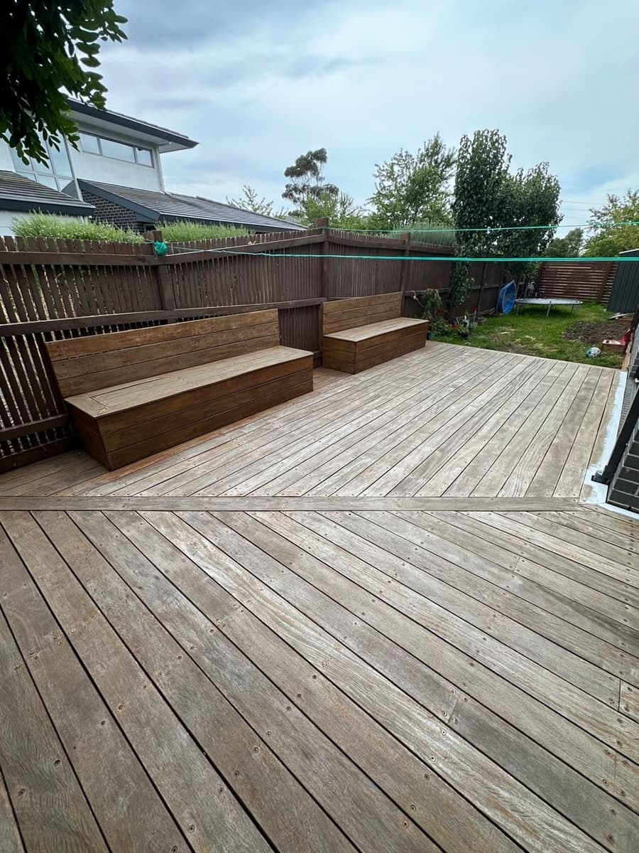 Weathered grey timber deck and built-in bench prior to restoration