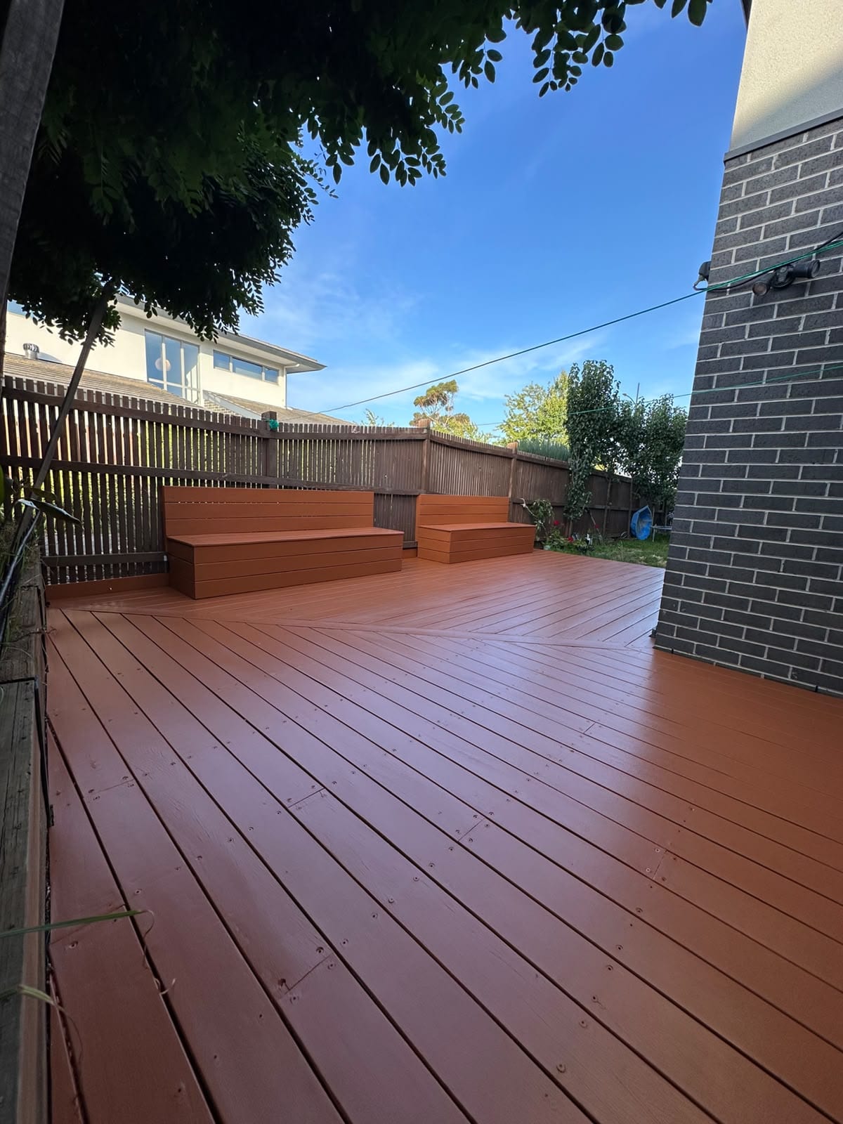 Restored outdoor timber deck and benches with rich cedar oil stain