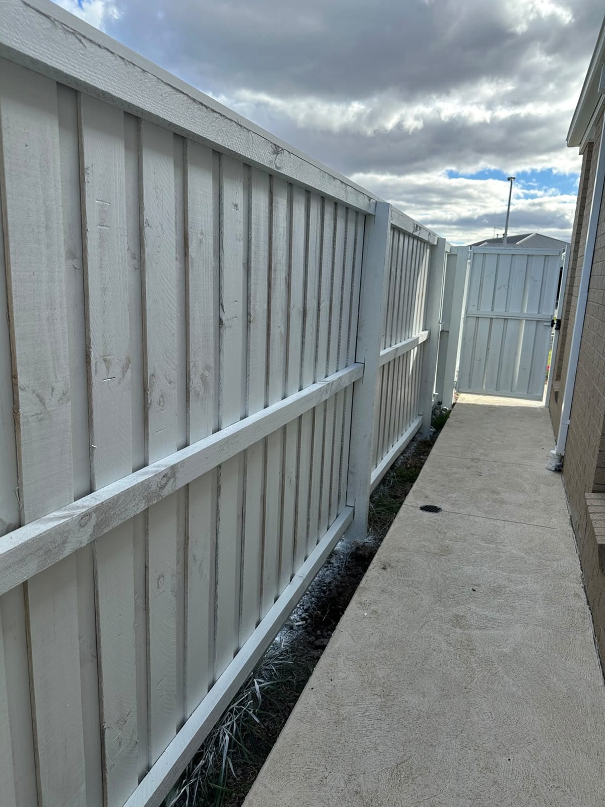 Airless spray application of premium white exterior fence paint