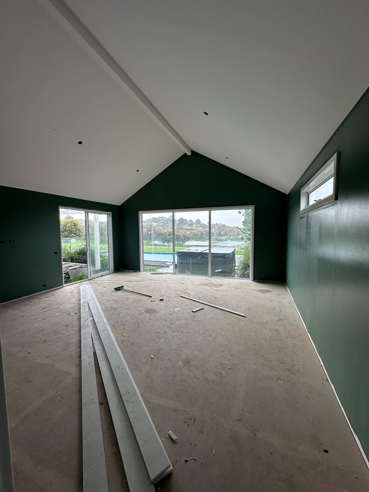Vaulted cathedral ceiling living room with forest green walls and white rafters