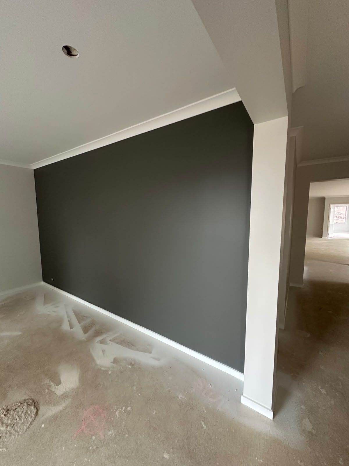 Deep charcoal accent wall framing natural timber floors