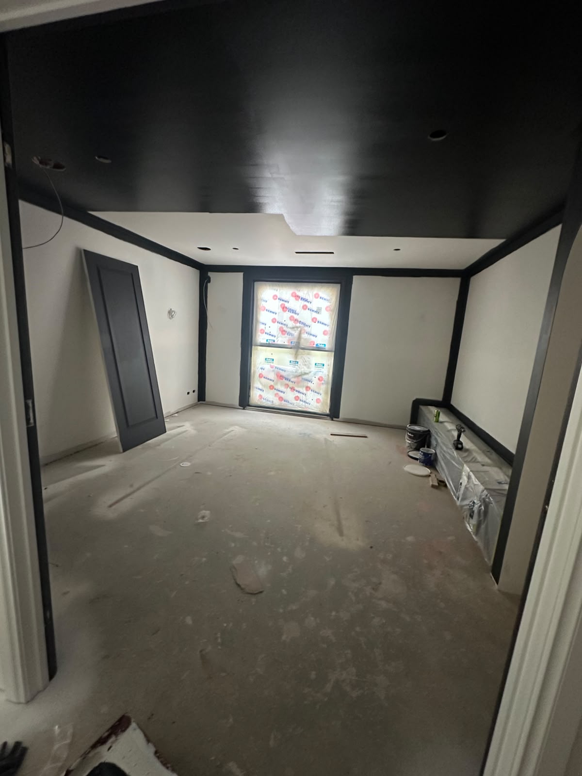 Dedicated home cinema room with matte black ceiling and dark door