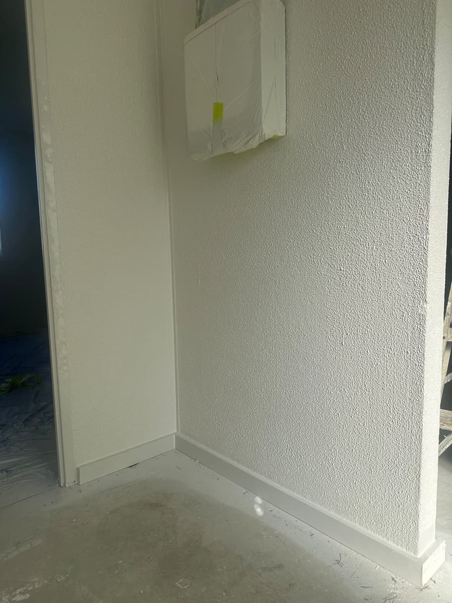 Fine textured acrylic render application in entrance corridor