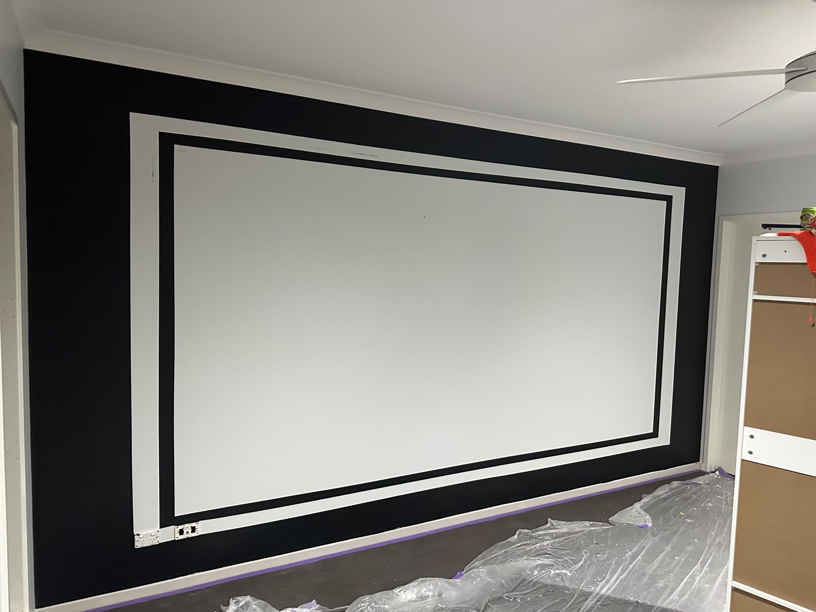 Theatre room feature wall with laser-sharp black and white border line