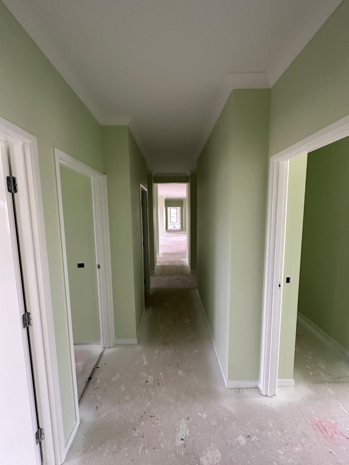Bedroom walls repainted in calming sage green with clean architraves