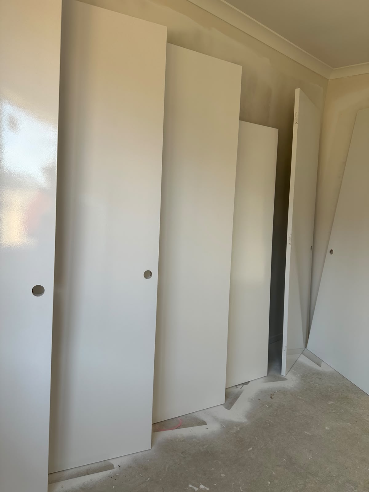 Factory-smooth spray-painted interior doors drying upright by ZN Painting Services